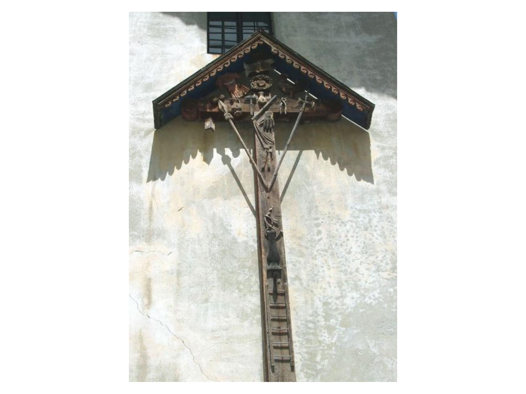Kreuz mit Foltgeräten auf die Fassade des Museums