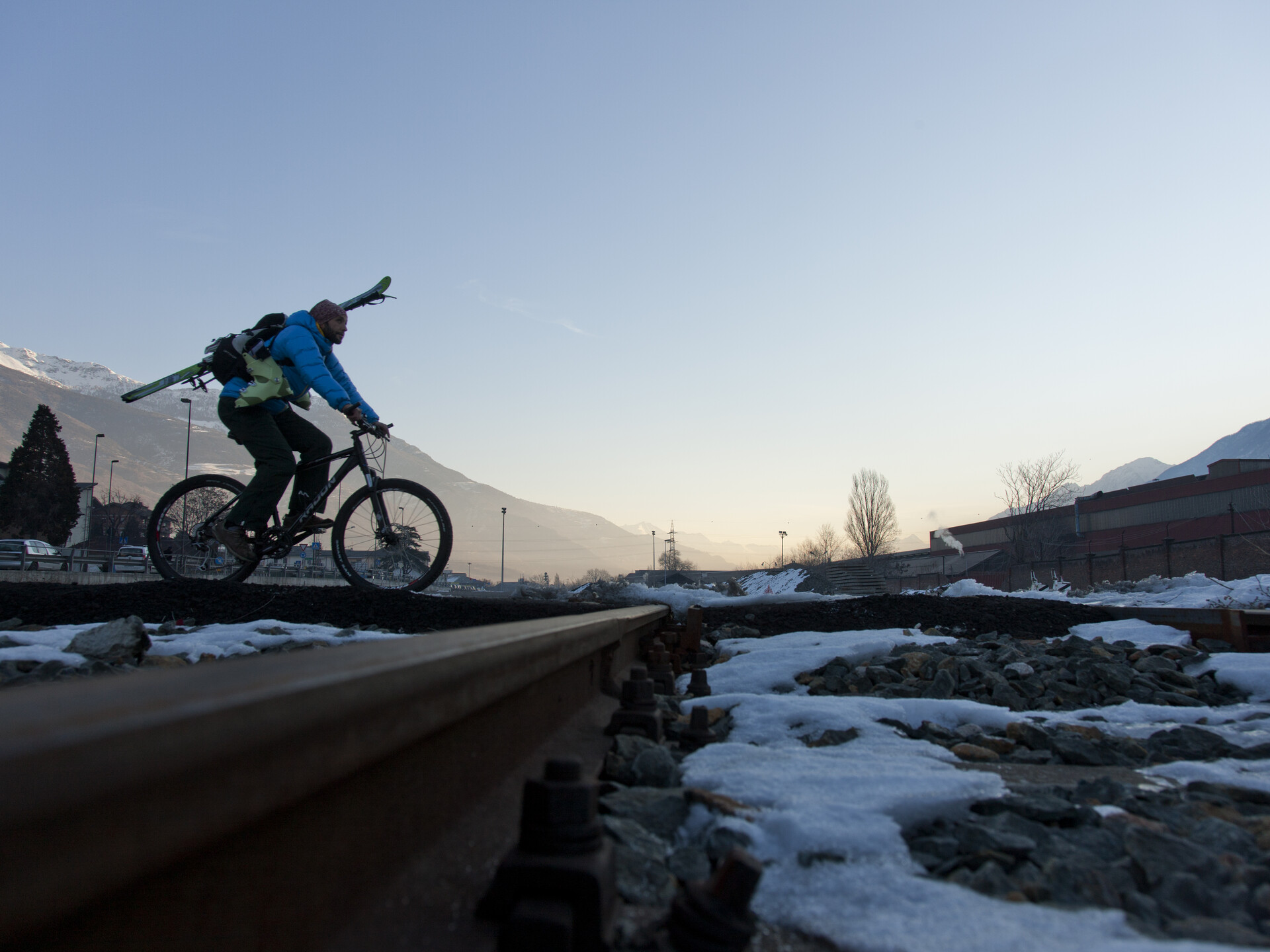 En vélo, transport des skis vers le départ de la télécabine Aoste-Pila